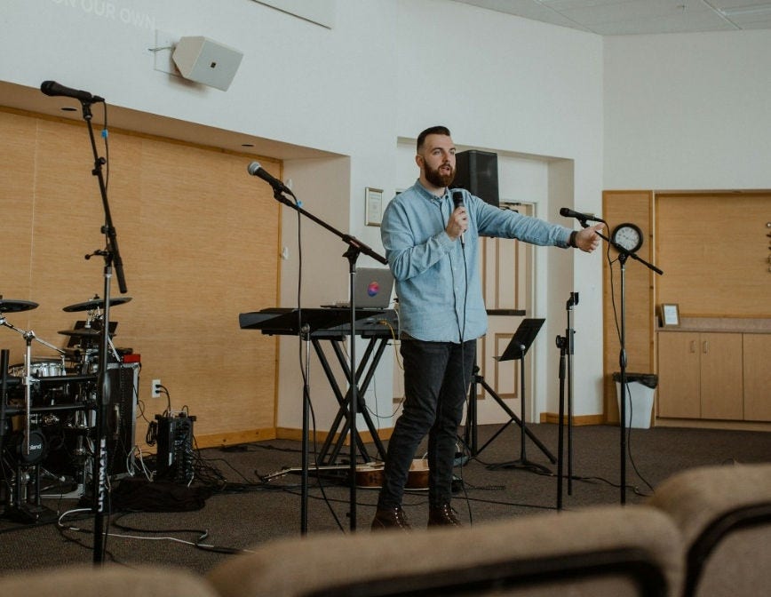 man standing on stage talking