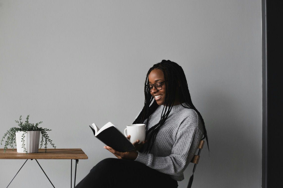 woman sitting reading a book with her coffee