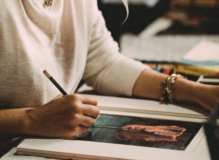 Person coloring a flower