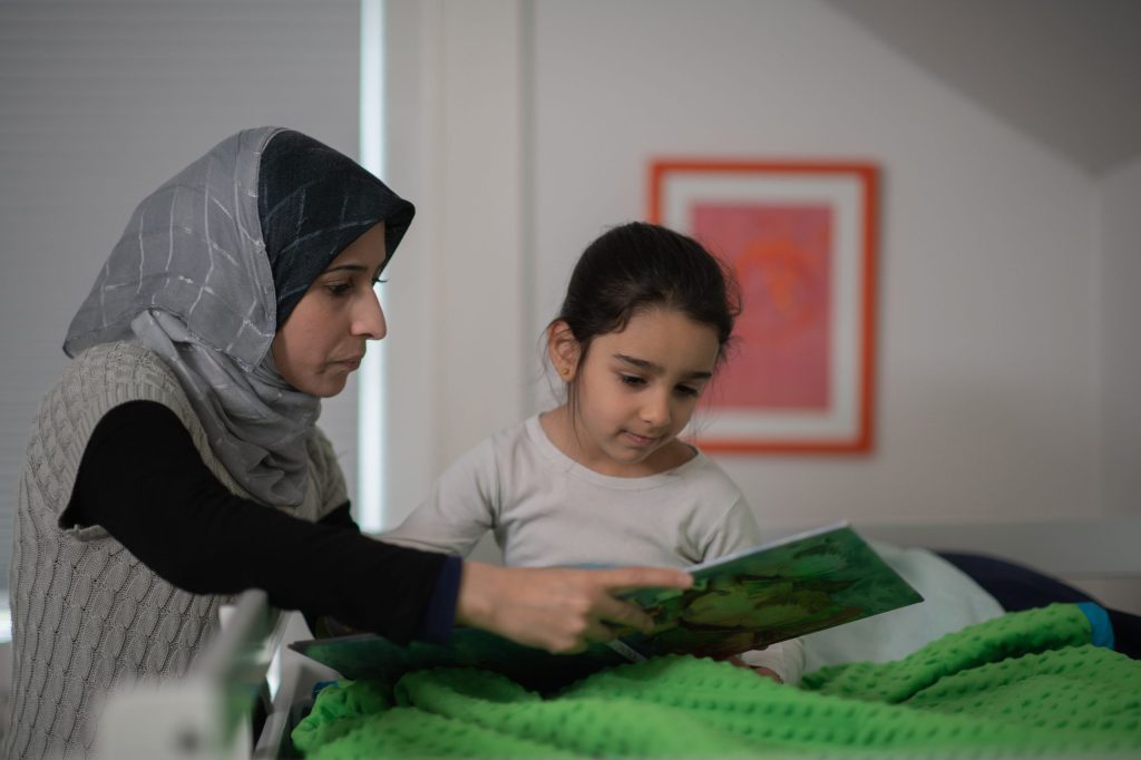 Muslim Mother Reading to Her Daughter stock photo