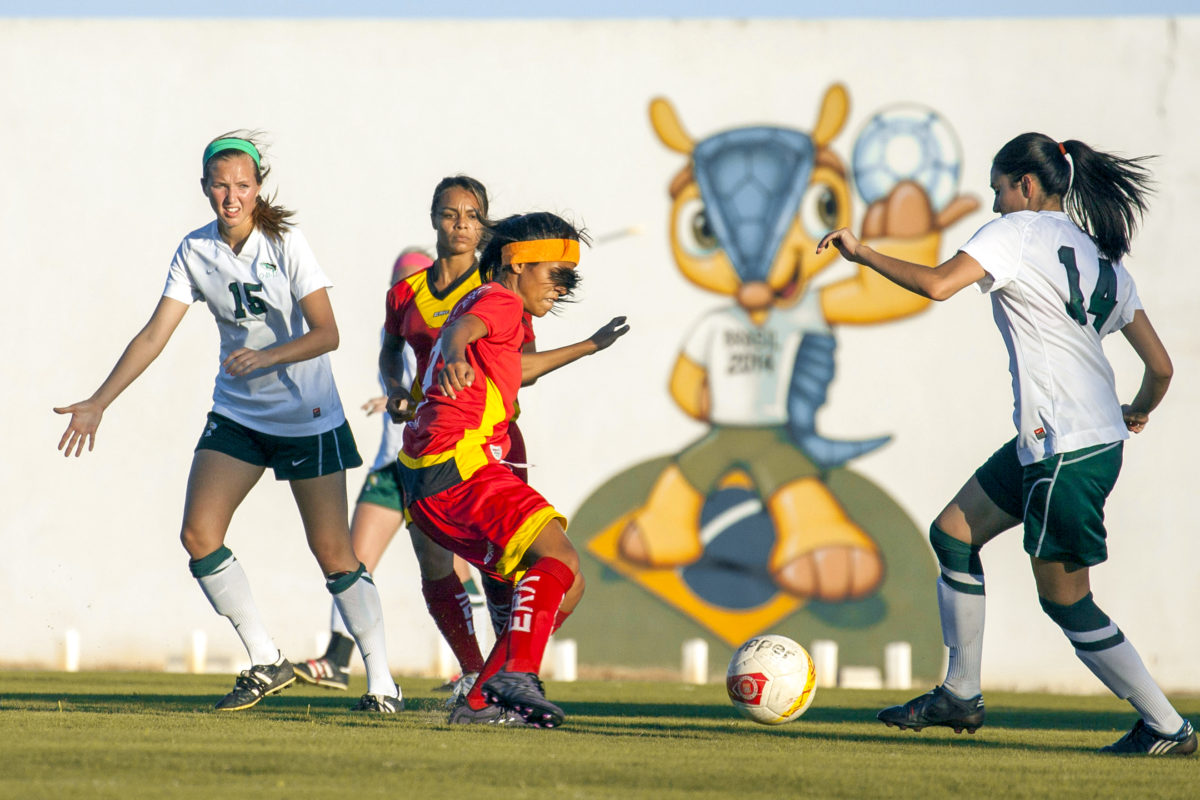 The Lady Bison of Oklahoma Baptist University (OBU), in white jerseys, show their teamwork skills in Ceará-Mirim, Brazil, beating a local Brazilian team 5-0. The exhibition game was an outreach event sponsored by a local church while the OBU team was on a mission trip to the area.
